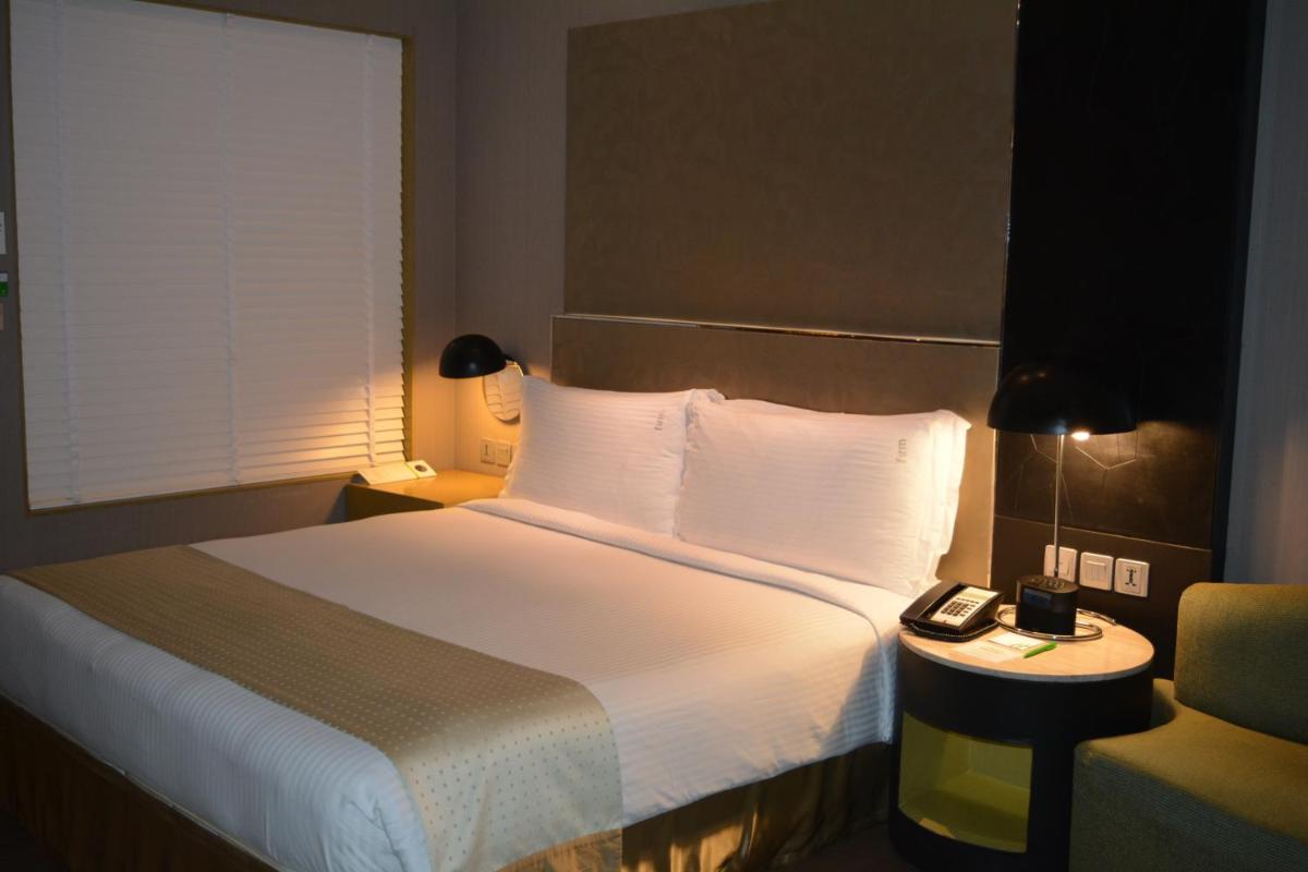 a hotel room with a bed and a phone on a table at Holiday Inn New Delhi Aerocity by IHG in New Delhi