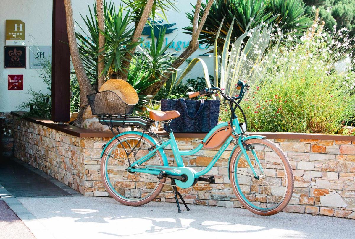 un vélo bleu garé à côté d'un mur de briques dans l'établissement Relais et Châteaux Thalasso & Spa Ile de la Lagune, à Saint-Cyprien