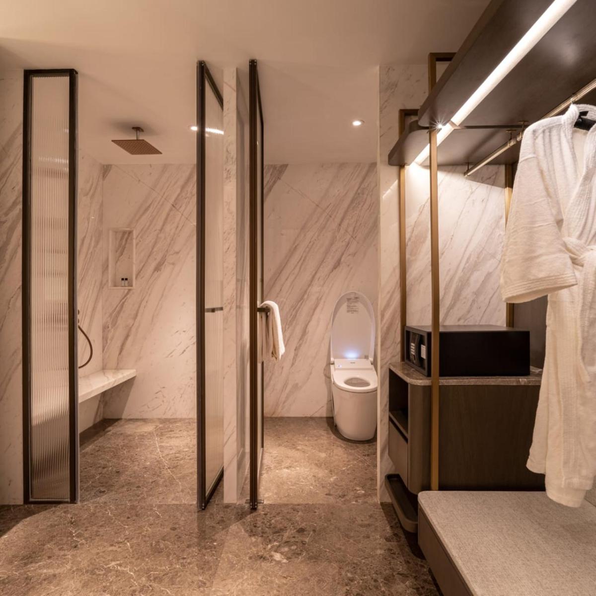 a bathroom with a toilet and a sink and a tub at The Residency Towers in Chennai