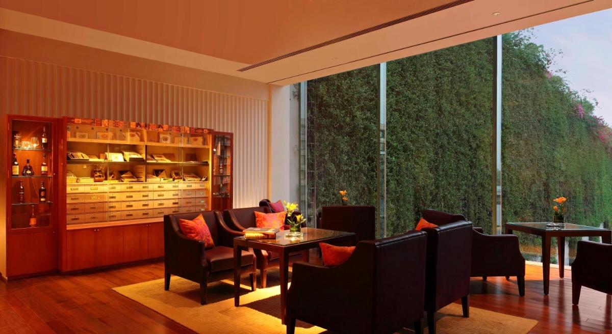 a restaurant with tables and chairs and a large window at The Oberoi Gurgaon in Gurgaon
