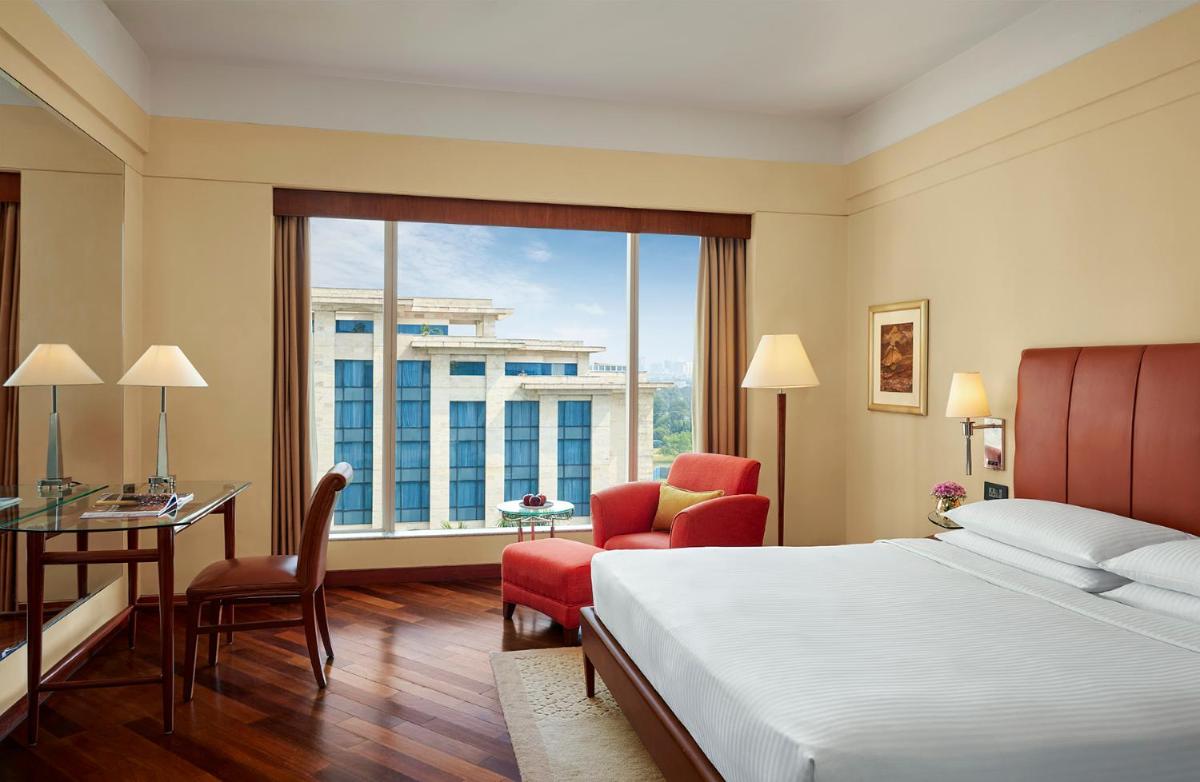 a hotel room with a bed and a desk and a window at Hyatt Regency Kolkata in Kolkata a hotel room with a bed and a desk and a window at Hyatt Regency Kolkata in Kolkata