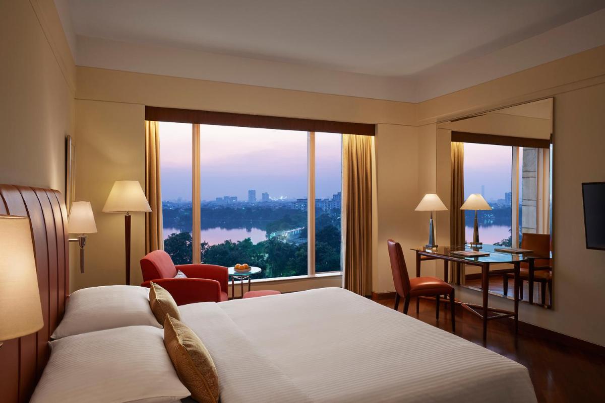a hotel room with a bed and a large window at Hyatt Regency Kolkata in Kolkata a hotel room with a bed and a large window at Hyatt Regency Kolkata in Kolkata