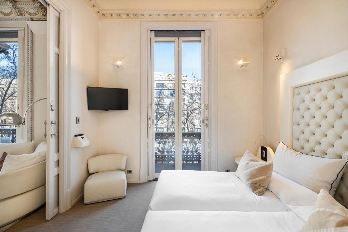 Una habitación de hotel con una cama y una ventana. en El Palauet Royal Suites, en Barcelona