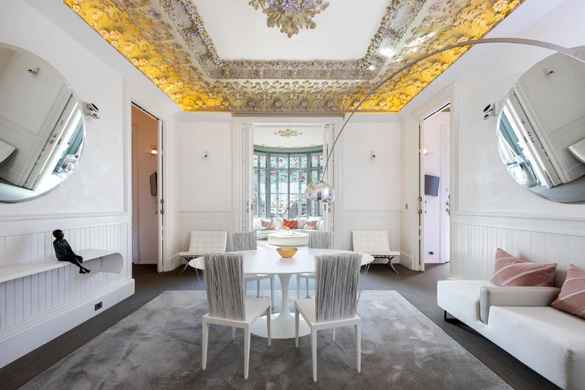 Un comedor con techo artesonado y una mesa y sillas. en El Palauet Royal Suites, en Barcelona