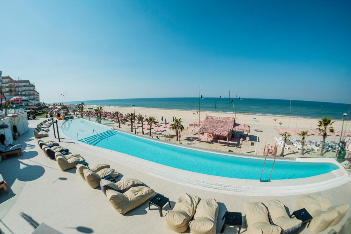 un complejo con piscina y playa en ON Hotels Oceanfront Adults Designed, en Matalascañas