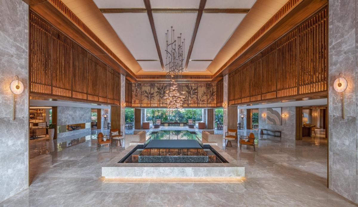 a lobby with a fountain in the middle of a room at JW Marriott Goa in Vagator a lobby with a fountain in the middle of a room at JW Marriott Goa in Vagator