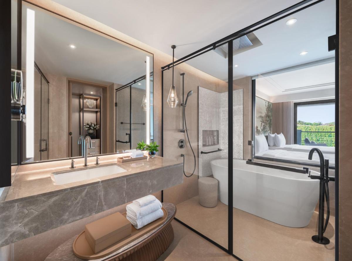 a bathroom with a tub and a sink and a bed at JW Marriott Goa in Vagator a bathroom with a tub and a sink and a bed at JW Marriott Goa in Vagator