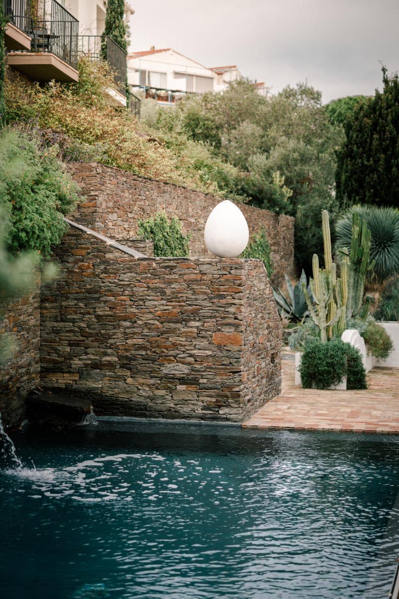 una pared de ladrillos al lado de un charco de agua en Boutique Hotel Villa Gala by Fimedhotels, en Cadaqués