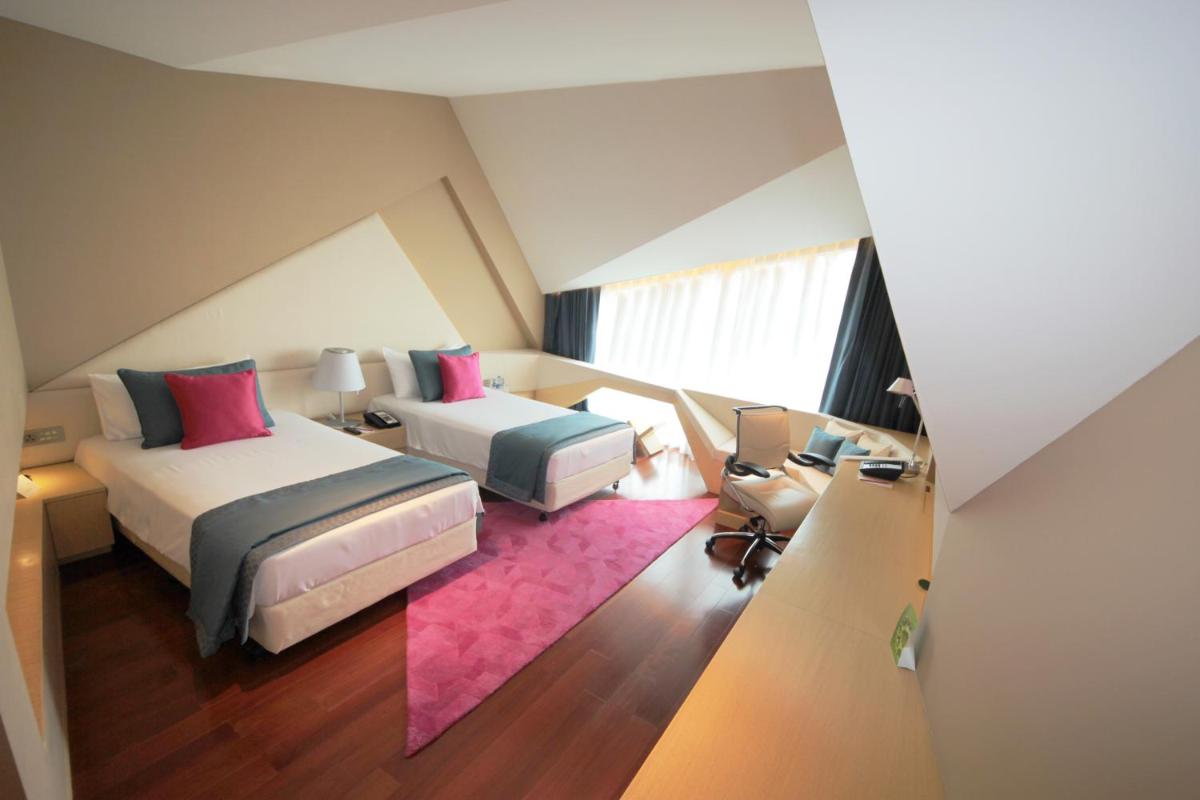 a bedroom with two beds and a pink rug at Vivanta New Delhi, Dwarka in New Delhi a bedroom with two beds and a pink rug at Vivanta New Delhi, Dwarka in New Delhi