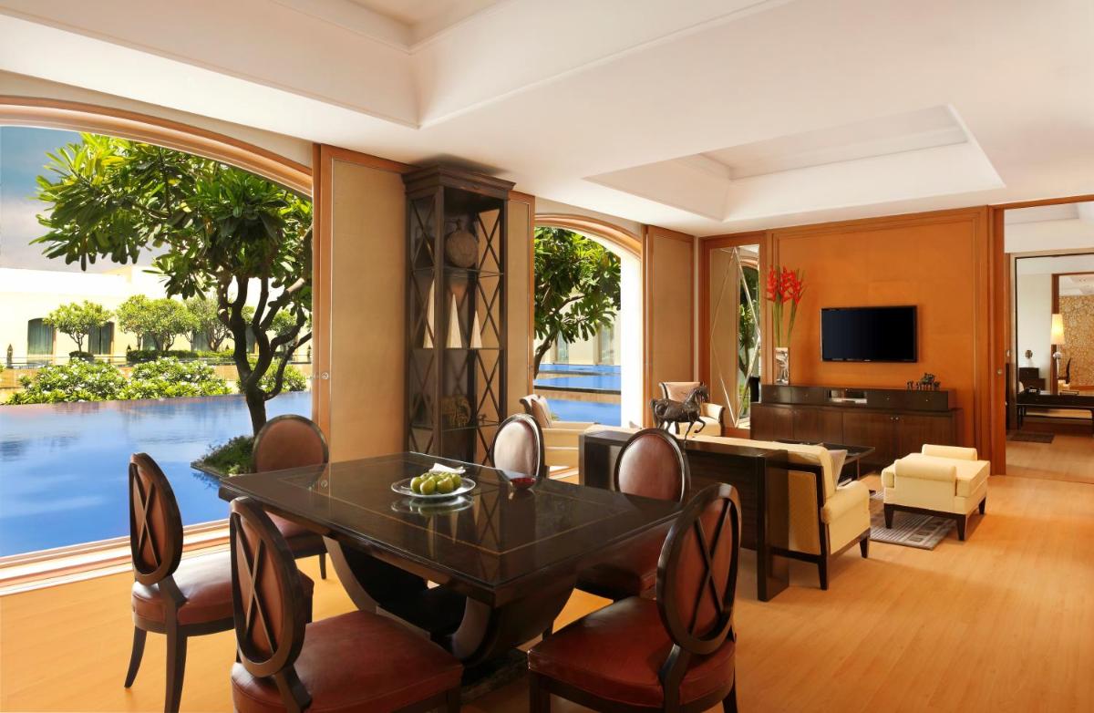 a living room with a table and chairs and a television at Trident Gurgaon in Gurgaon