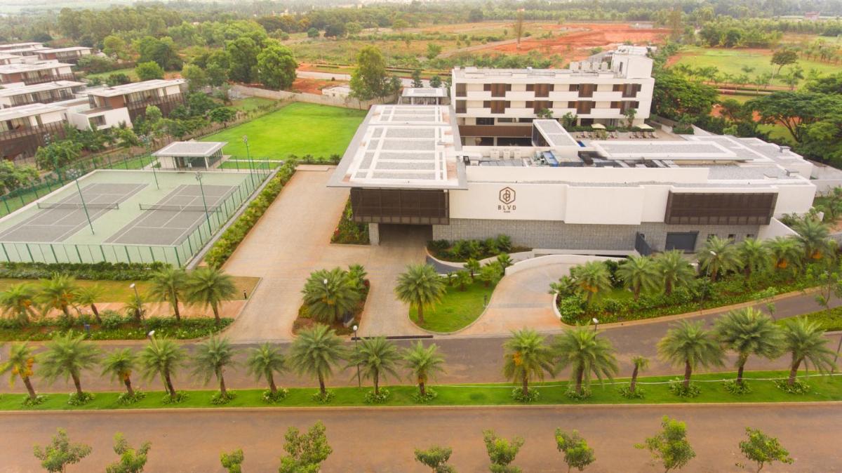 an aerial view of a building with palm trees at BLVD Club - Near BENGALURU AIRPORT in Bengaluru an aerial view of a building with palm trees at BLVD Club - Near BENGALURU AIRPORT in Bengaluru