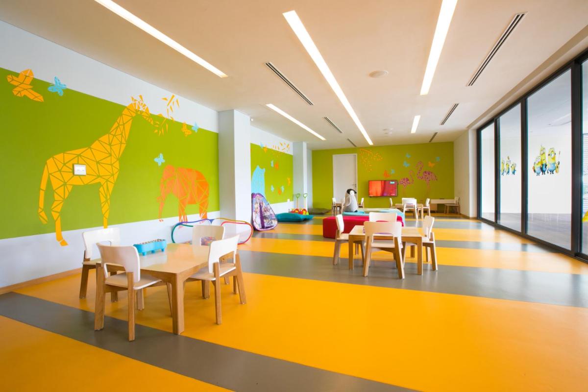 a dining room with a giraffe mural on the wall at BLVD Club - Near BENGALURU AIRPORT in Bengaluru