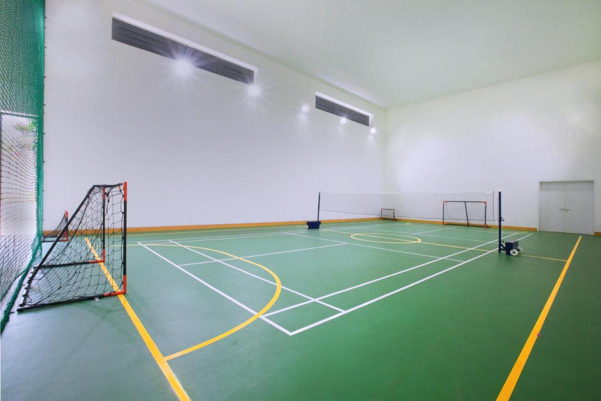 a gym with a tennis court with a net at BLVD Club - Near BENGALURU AIRPORT in Bengaluru