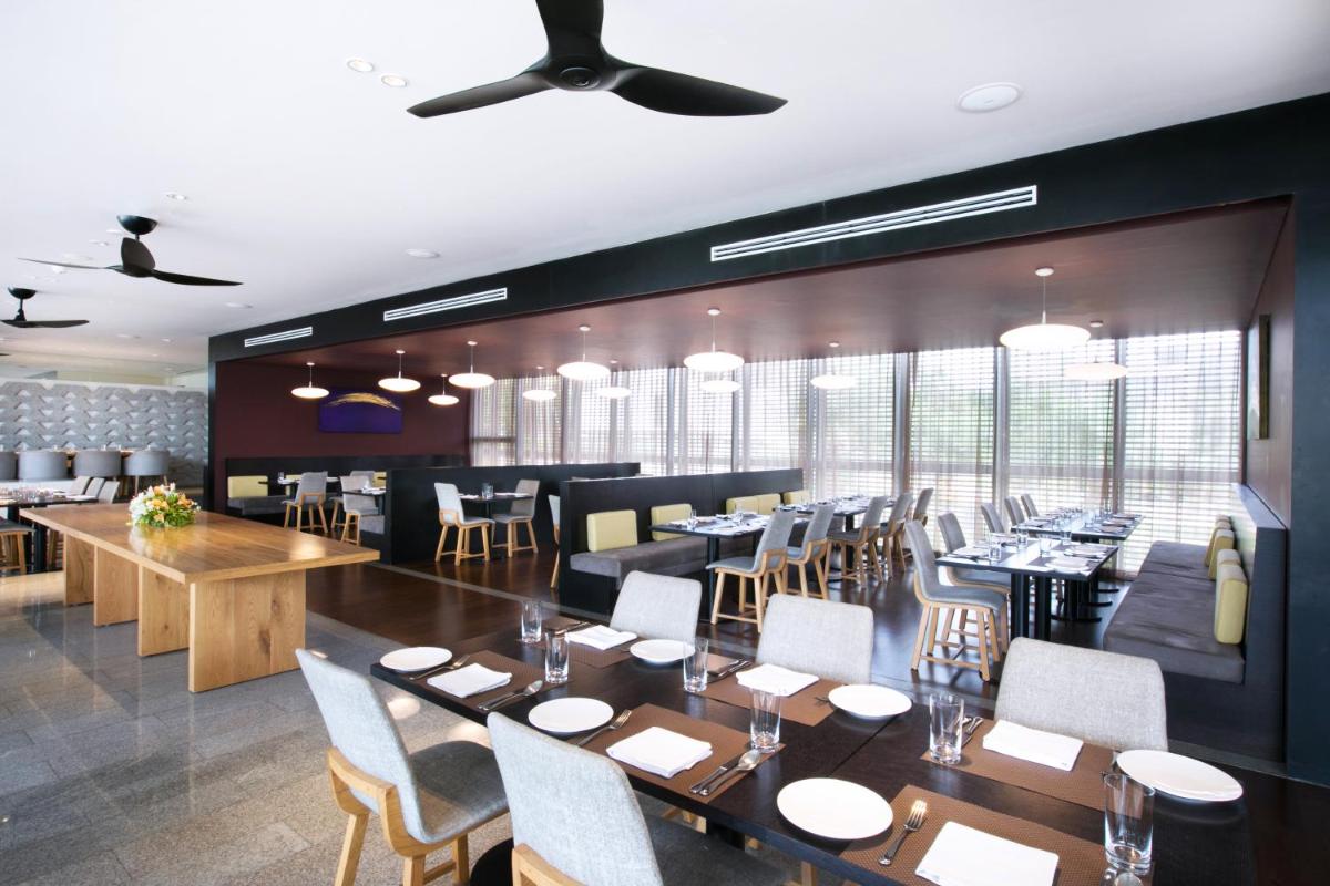 a dining room with tables and chairs in a restaurant at BLVD Club - Near BENGALURU AIRPORT in Bengaluru