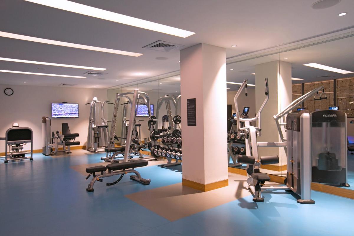 a gym with treadmills and machines in a room at BLVD Club - Near BENGALURU AIRPORT in Bengaluru