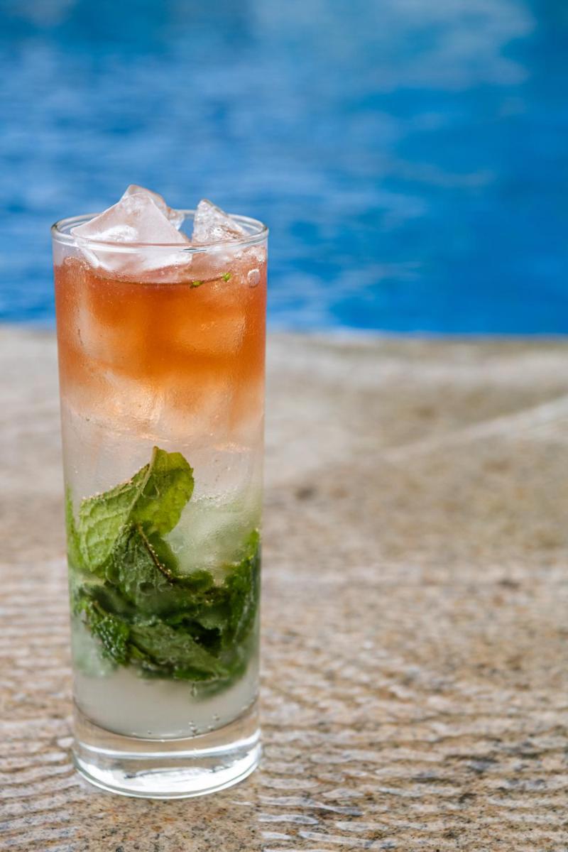 a drink with mint on a table next to a pool at BLVD Club - Near BENGALURU AIRPORT in Bengaluru