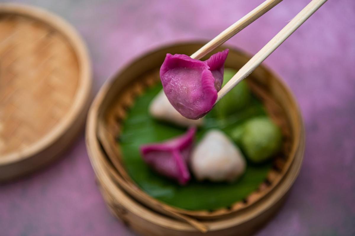 a bowl of food with a purple flower and chopsticks at BLVD Club - Near BENGALURU AIRPORT in Bengaluru
