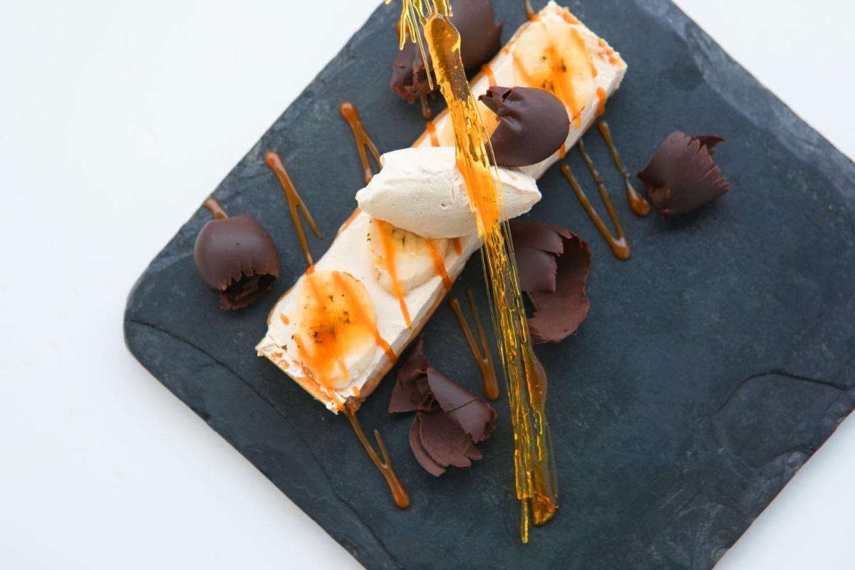 a black plate with some food on top at BLVD Club - Near BENGALURU AIRPORT in Bengaluru