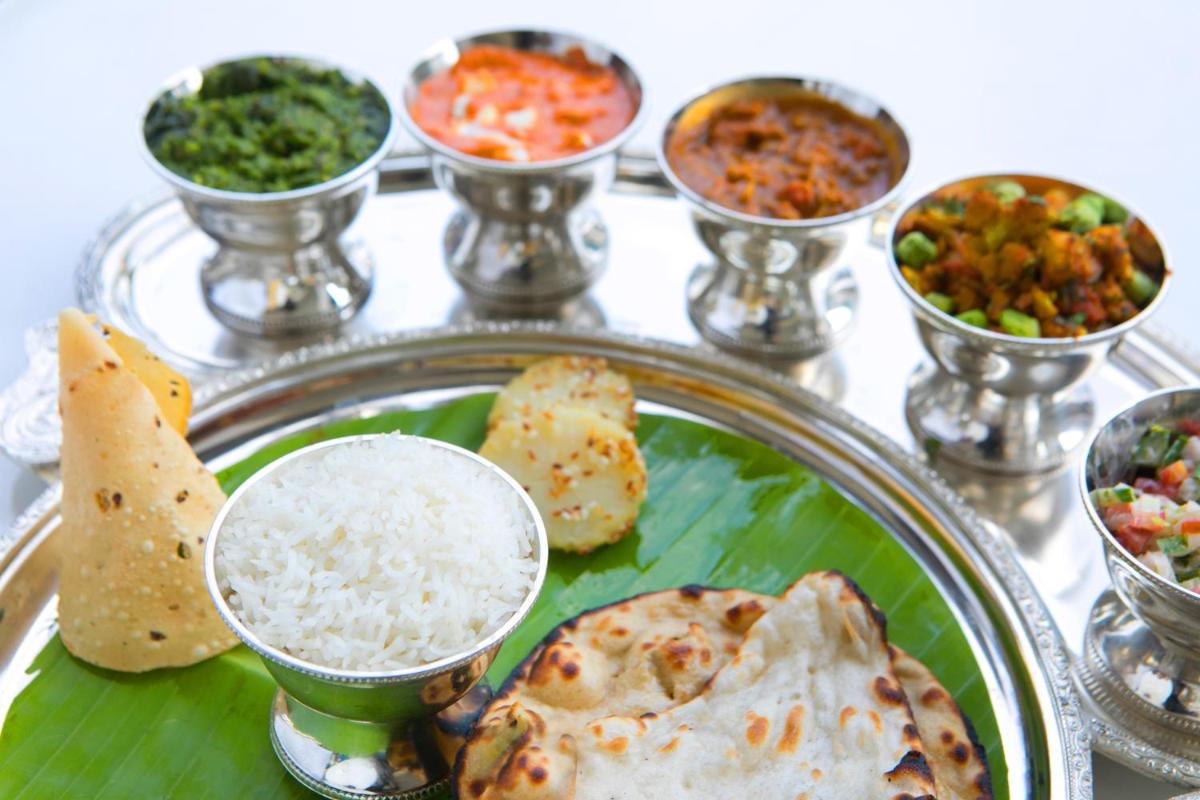 a plate of food with rice and different types of food at BLVD Club - Near BENGALURU AIRPORT in Bengaluru