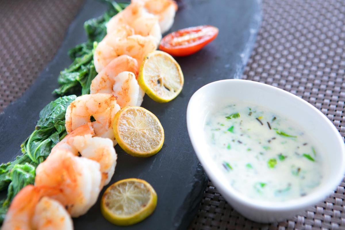 a plate with shrimp and a bowl of dipping sauce at BLVD Club - Near BENGALURU AIRPORT in Bengaluru