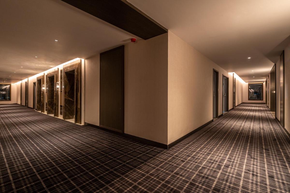 an empty hallway of a building with lights on at The Residency Towers in Chennai