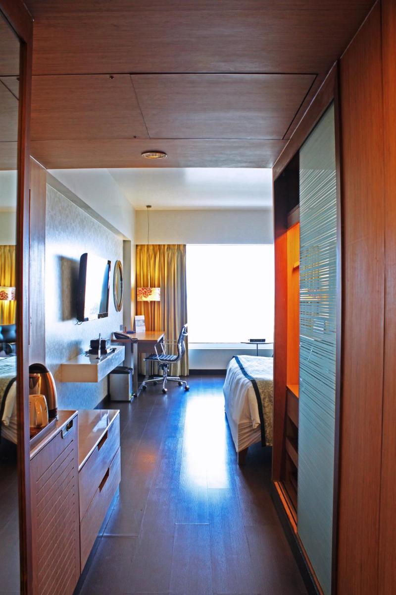 a bedroom with a bed and a desk and a table at Fortune Select SG Highway, Ahmedabad - Member ITC Hotels' Group in Ahmedabad