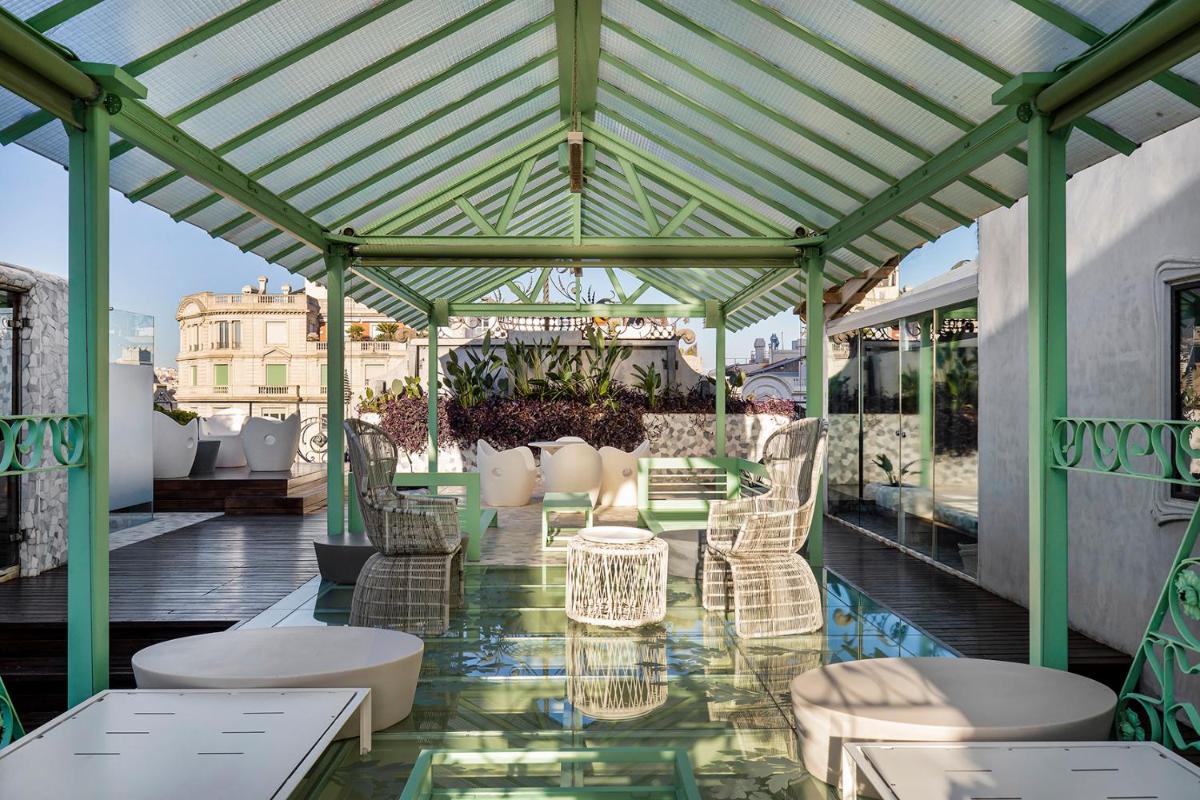 Un patio con sillas y mesas en un tejado. en El Palauet Royal Suites, en Barcelona