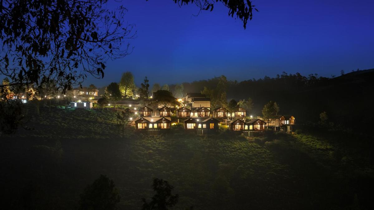a house lit up at night with lights at WelcomHeritage Ayatana Ooty in Ooty