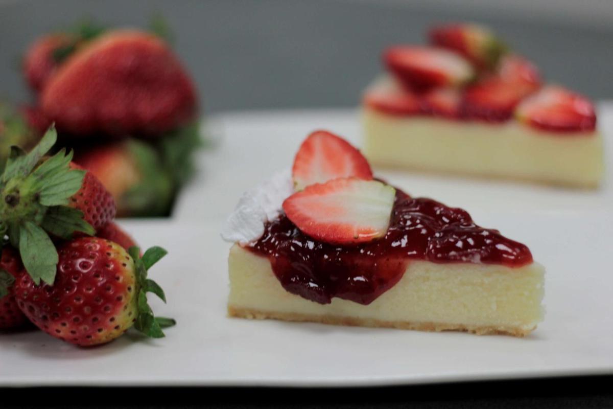 a piece of cheesecake with strawberries on a white plate at Hyatt Regency Amritsar Hotel & Spa in Amritsar
