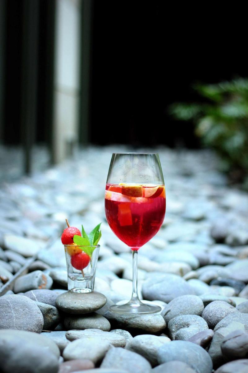 a glass of wine and a vase with strawberries in it at Hyatt Regency Amritsar Hotel & Spa in Amritsar