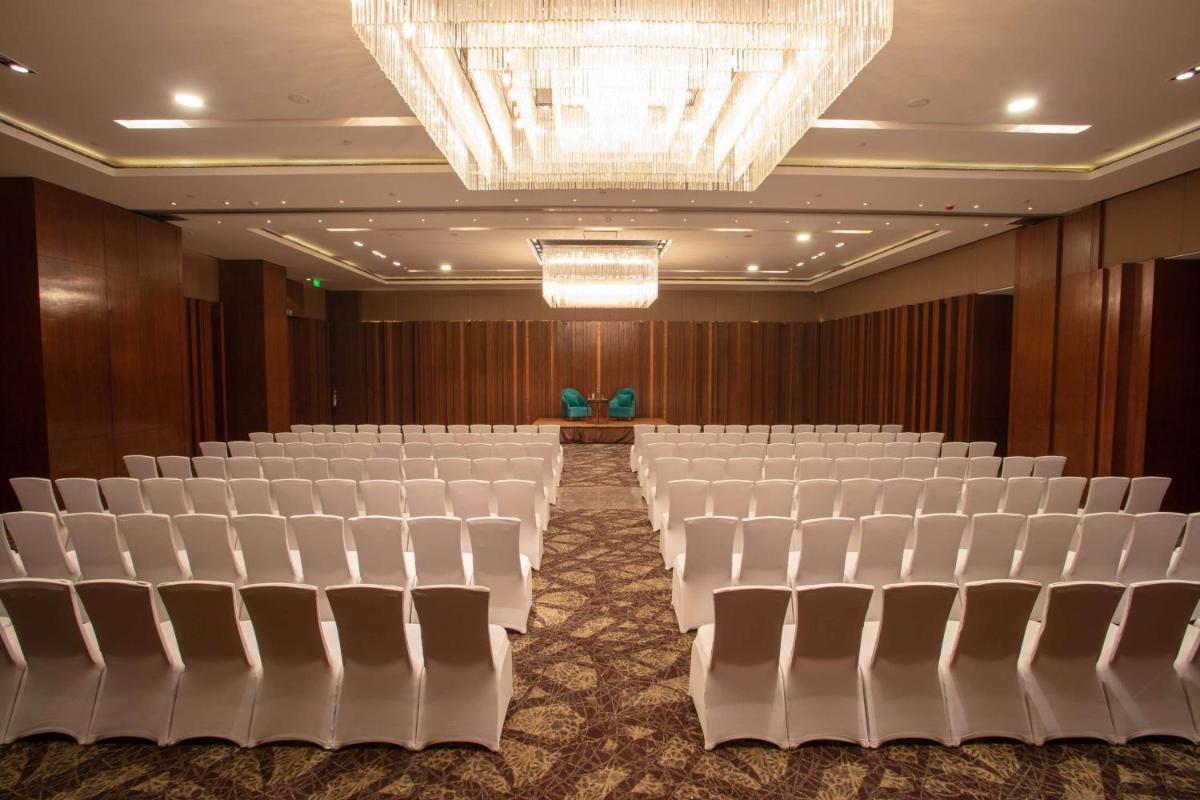 an empty hall with white chairs and a chandelier at Hyatt Regency Amritsar Hotel & Spa in Amritsar