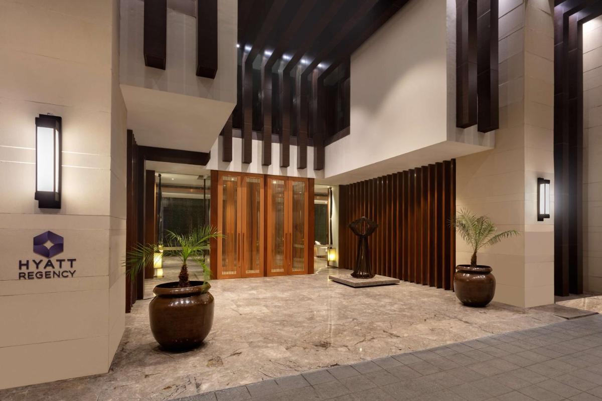 a lobby with two potted plants in a building at Hyatt Regency Amritsar Hotel & Spa in Amritsar