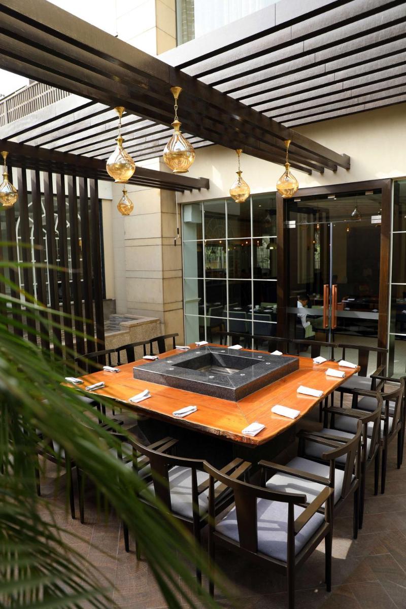 a wooden table and chairs on a patio at Hyatt Regency Amritsar Hotel & Spa in Amritsar