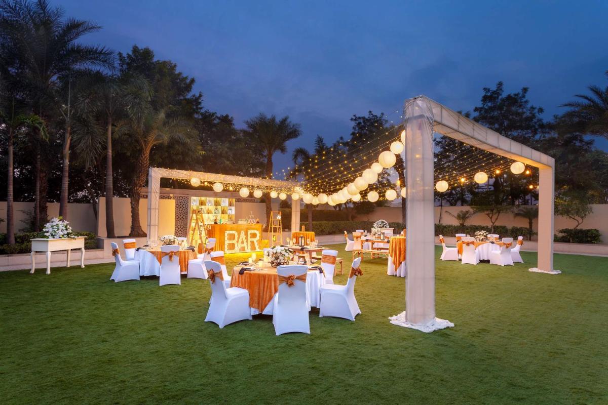 a group of tables and chairs in a field with lights at Hyatt Regency Amritsar Hotel & Spa in Amritsar