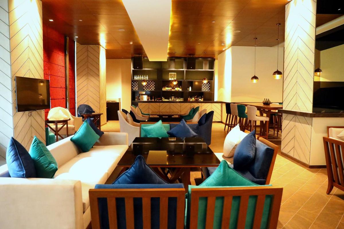 a living room with couches and a dining room at Hyatt Regency Amritsar Hotel & Spa in Amritsar