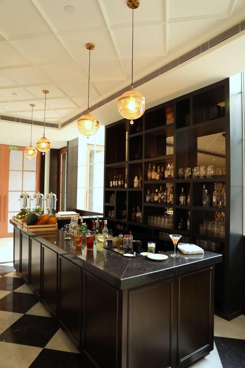 a large bar in a restaurant with a counter at Hyatt Regency Amritsar Hotel & Spa in Amritsar