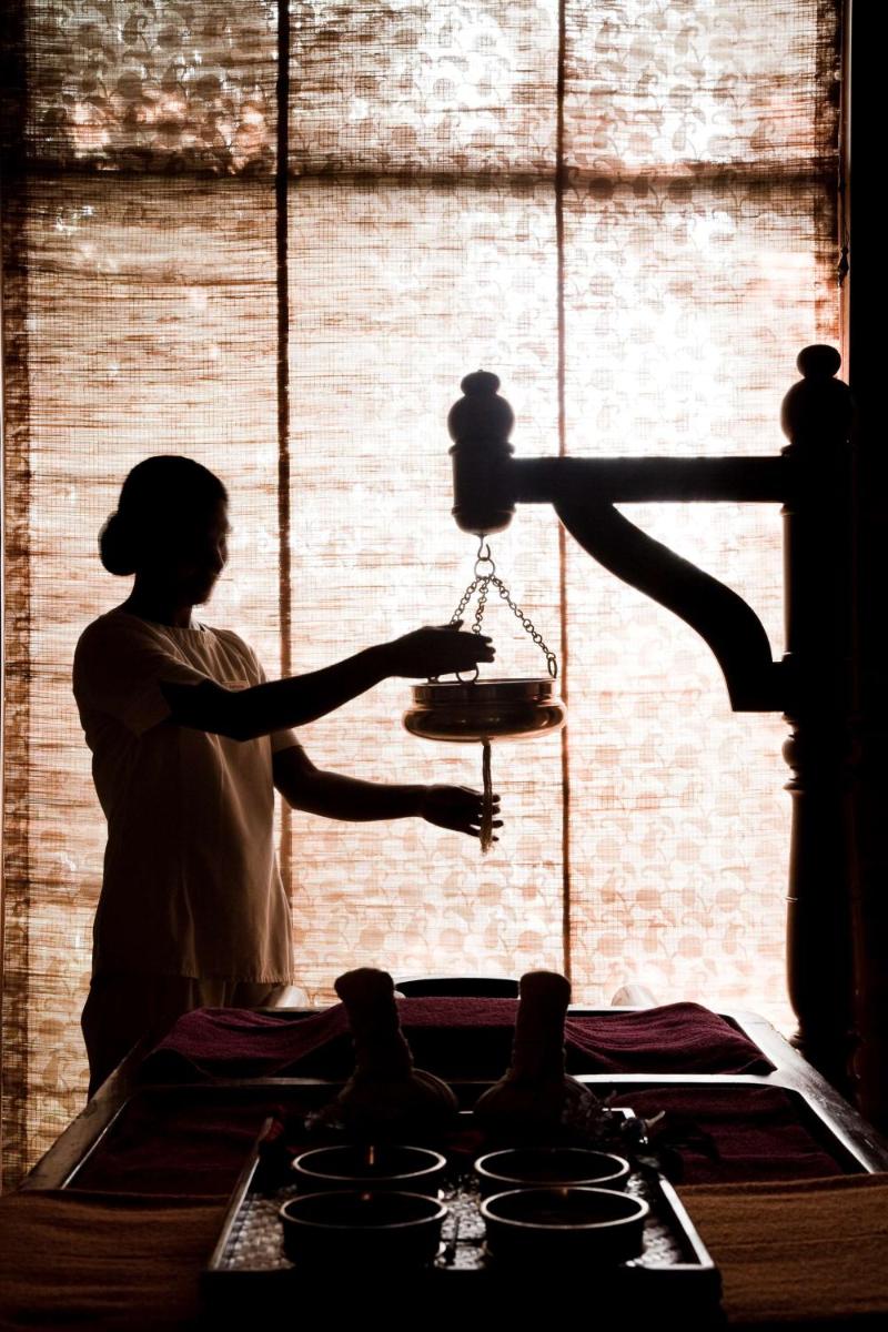 a woman holding a scale in front of a stove at Hyatt Regency Amritsar Hotel & Spa in Amritsar