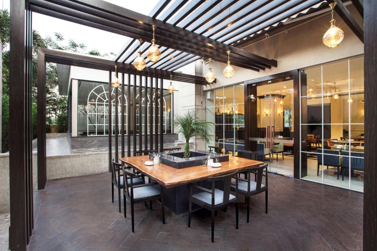 a dining room with a wooden table and chairs at Hyatt Regency Amritsar Hotel & Spa in Amritsar
