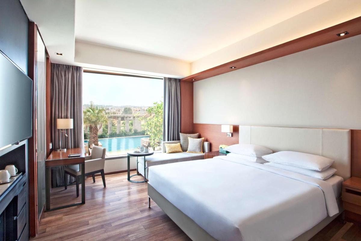 a hotel room with a large bed and a desk at Hyatt Regency Amritsar Hotel & Spa in Amritsar