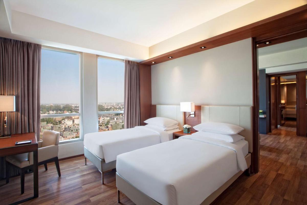 a hotel room with two beds and a window at Hyatt Regency Amritsar Hotel & Spa in Amritsar