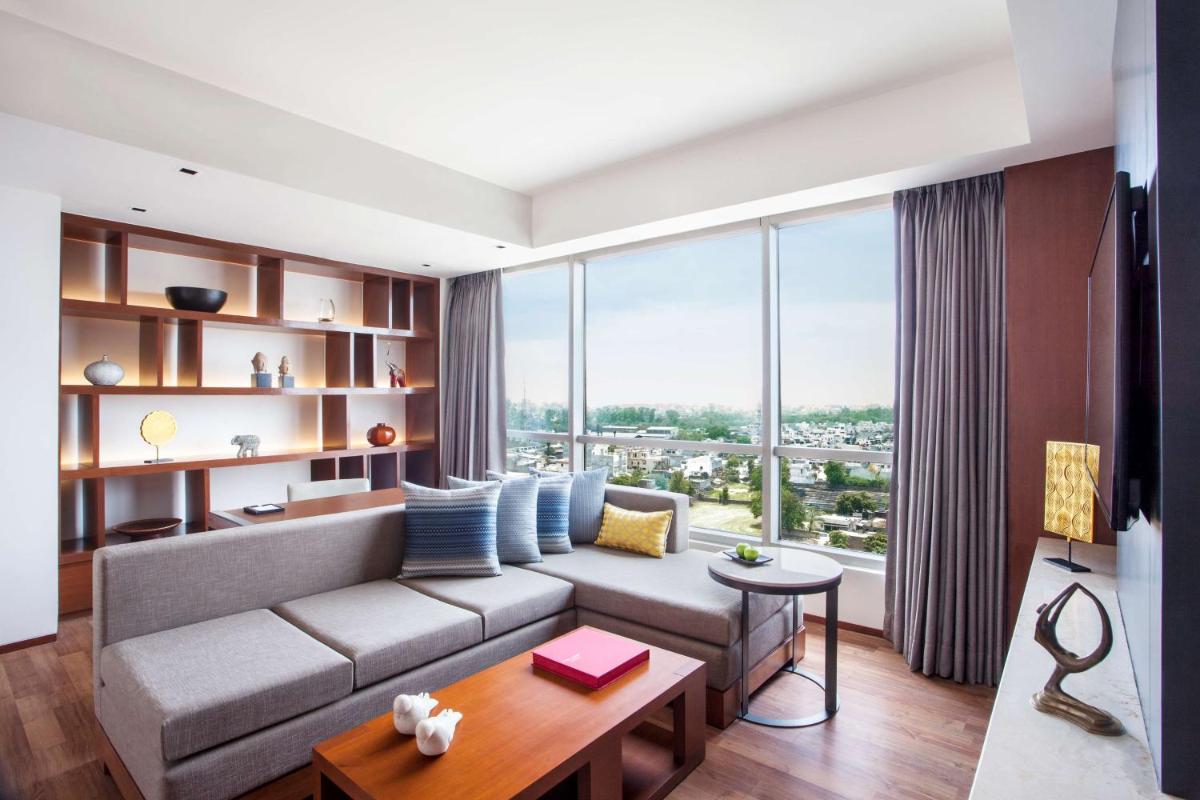 a living room with a couch and a large window at Hyatt Regency Amritsar Hotel & Spa in Amritsar