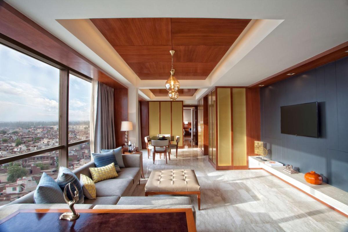 a living room with a couch and a tv at Hyatt Regency Amritsar Hotel & Spa in Amritsar