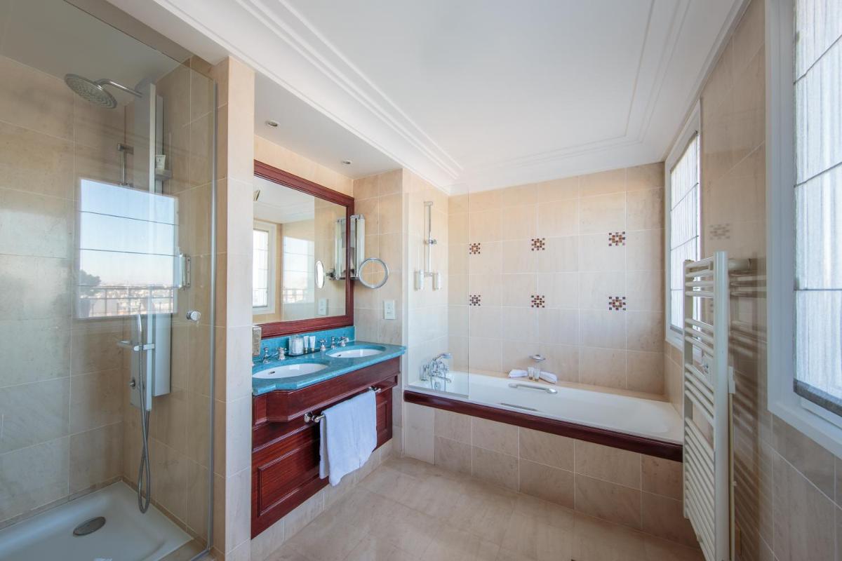 une salle de bain avec une baignoire et un lavabo et une baignoire dans l'établissement Hôtel Pont Royal Paris, à Paris