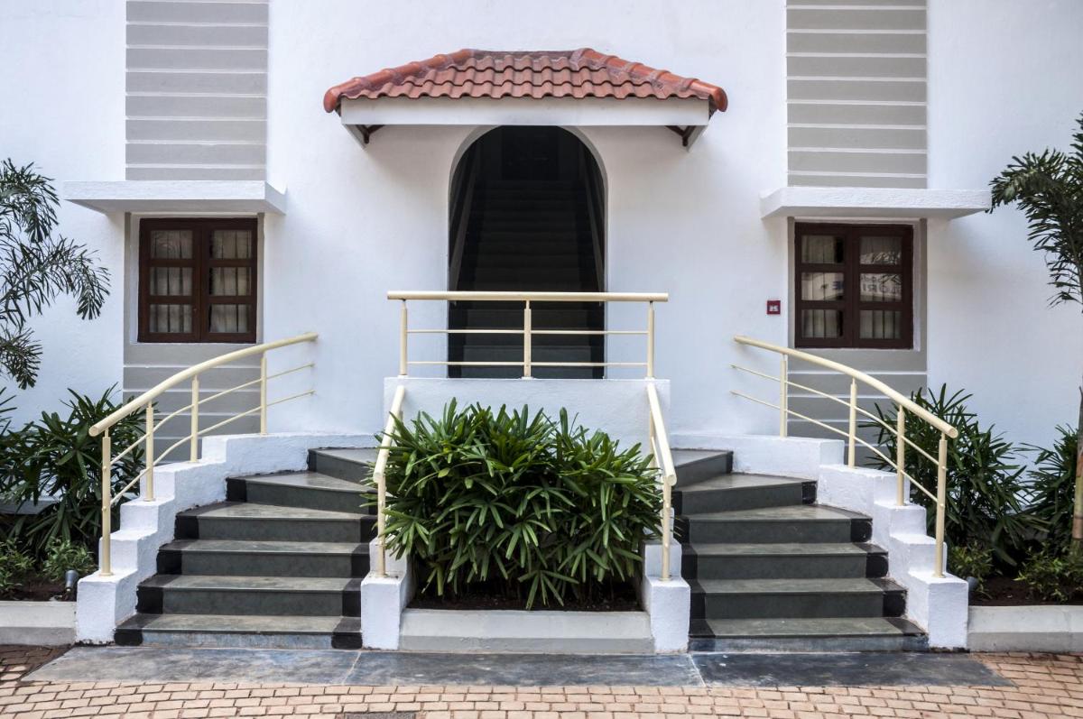 a white house with stairs in front of it at Radisson Goa Candolim in Candolim