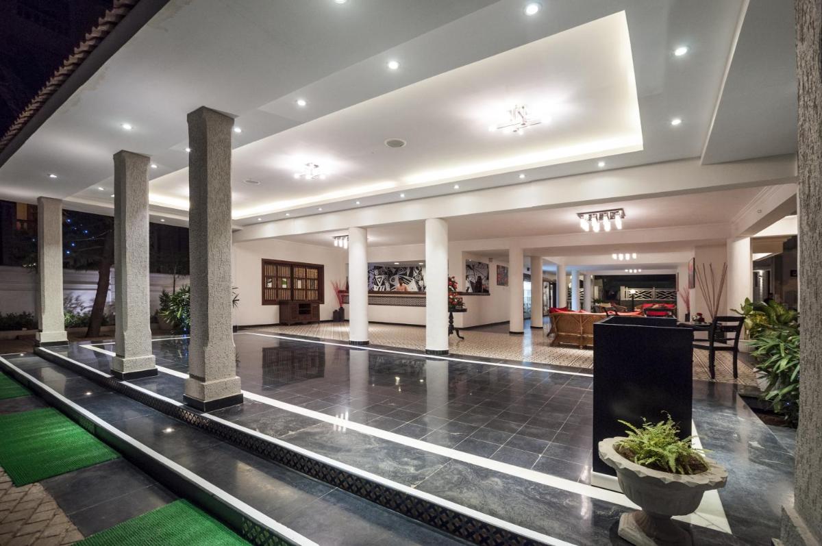 a lobby of a hotel with columns and a pool at Radisson Goa Candolim in Candolim