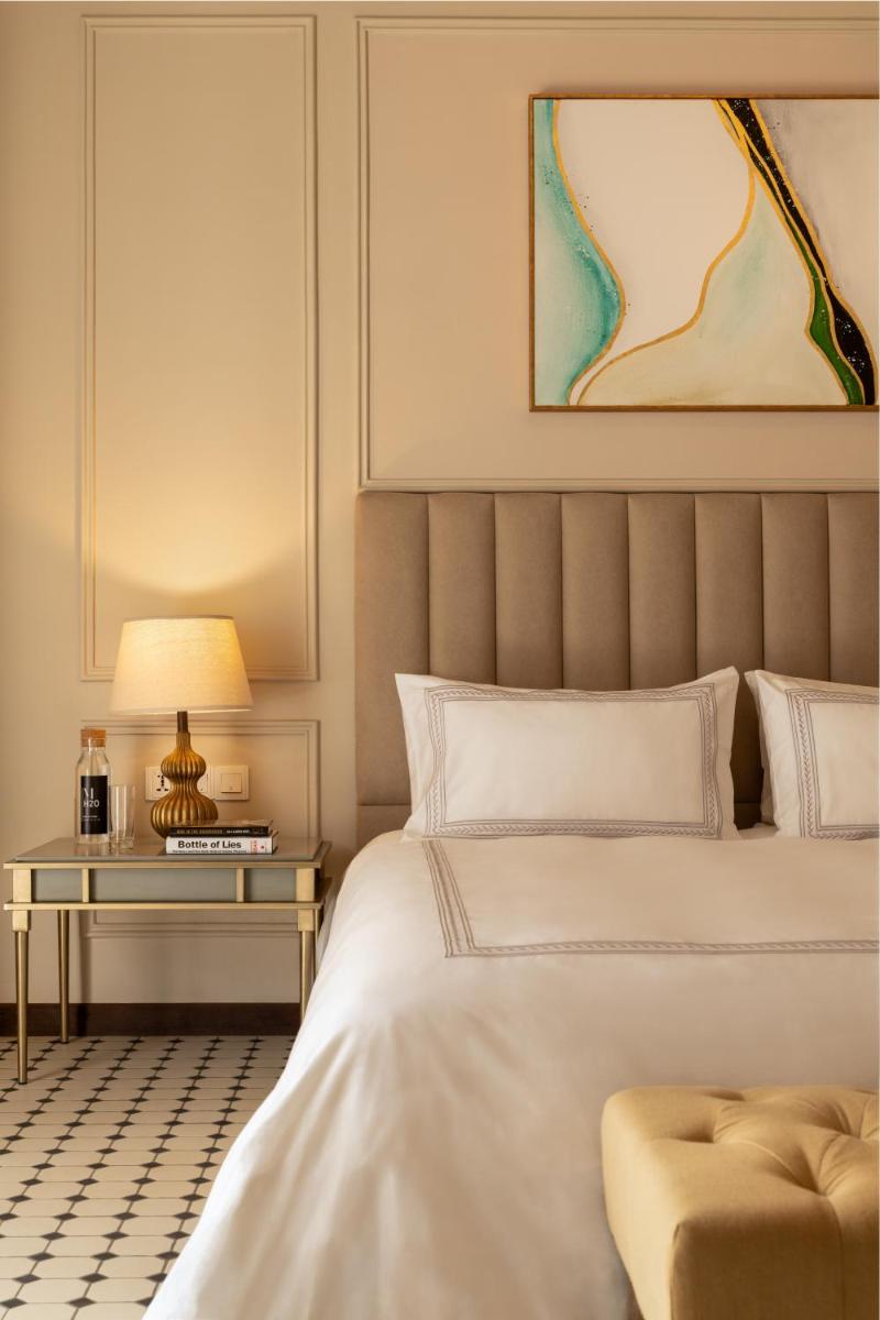a bedroom with a bed and a table with a lamp at MansionHaus in Anjuna