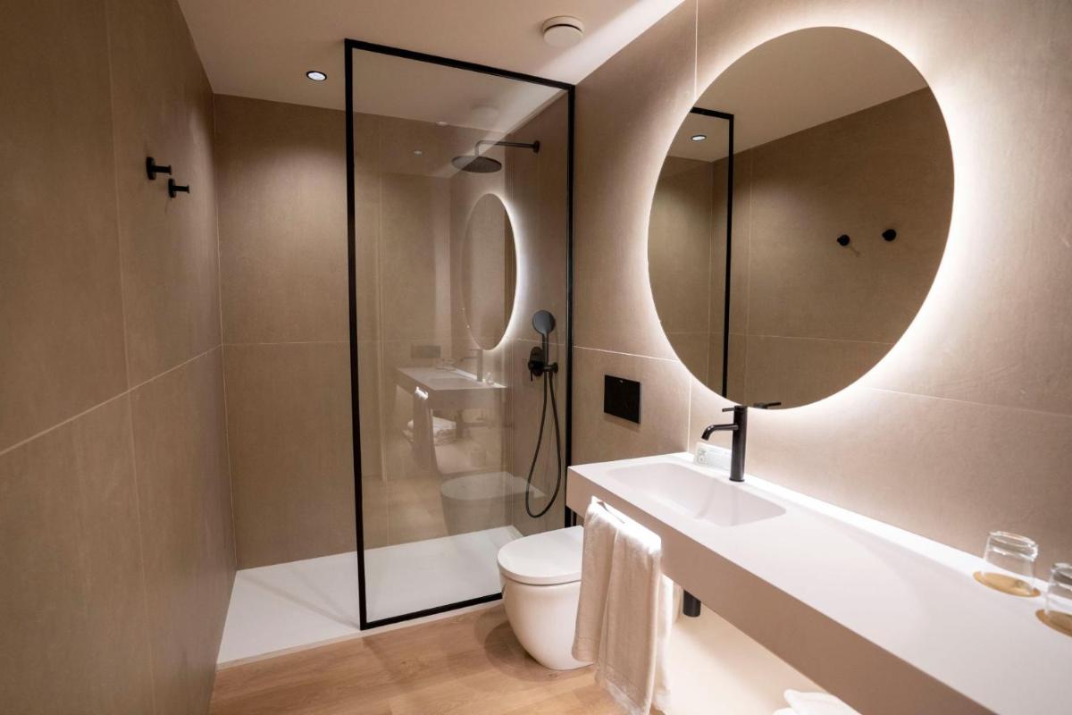 Un baño con inodoro y un espejo grande. en Seth Port Ciutadella, en Ciutadella 75 fotos más