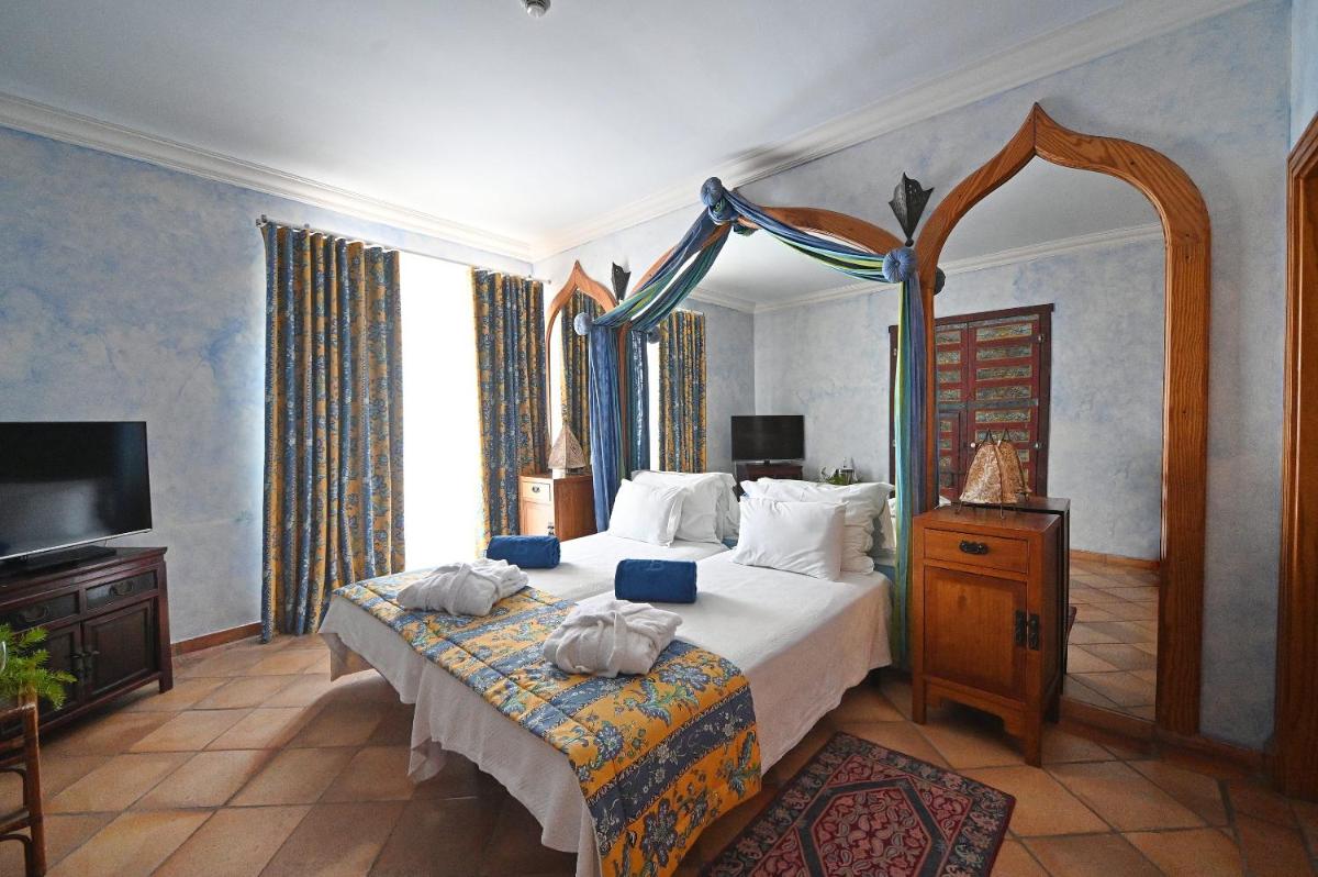 um quarto com uma cama grande e uma televisão em Boa Vista Hotel & Spa - Adults Only em Albufeira