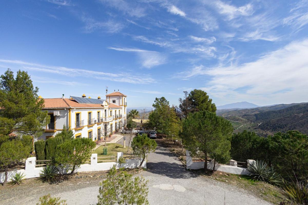 una casa en una colina con montañas al fondo en Cerro de Hijar, en Tolox