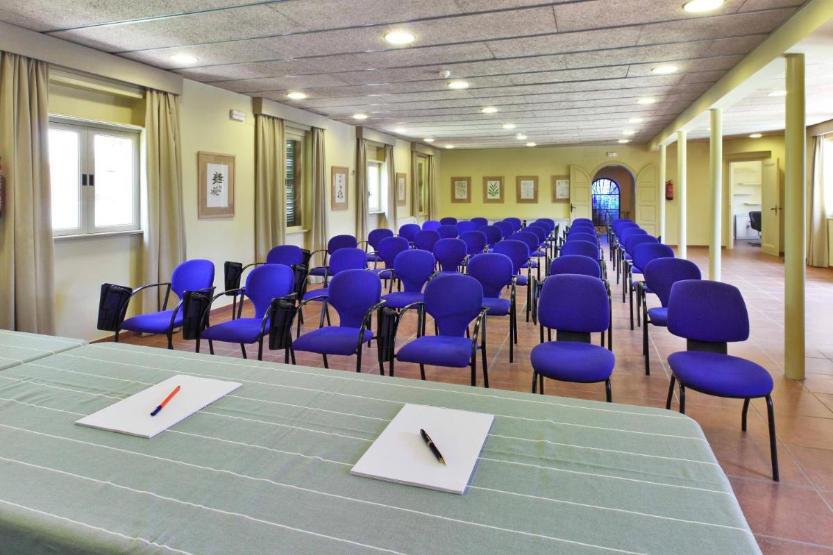 una sala de conferencias con sillas azules, mesa y sidx sidx sidx en Aparthotel Ciutat de Palol, en Platja d'Aro 58 fotos más